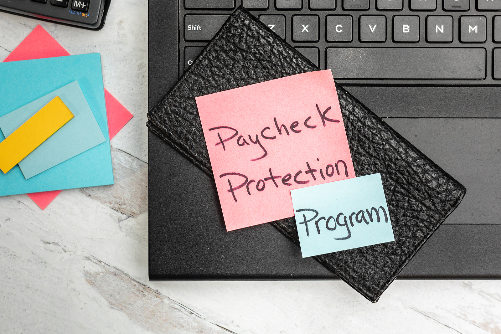 a notebook with sticky notes, paycheck protection program